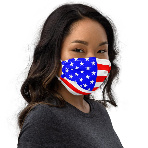 A woman with brown hair wearing a premium white face mask with the United States of America flag imprinted red white and blue